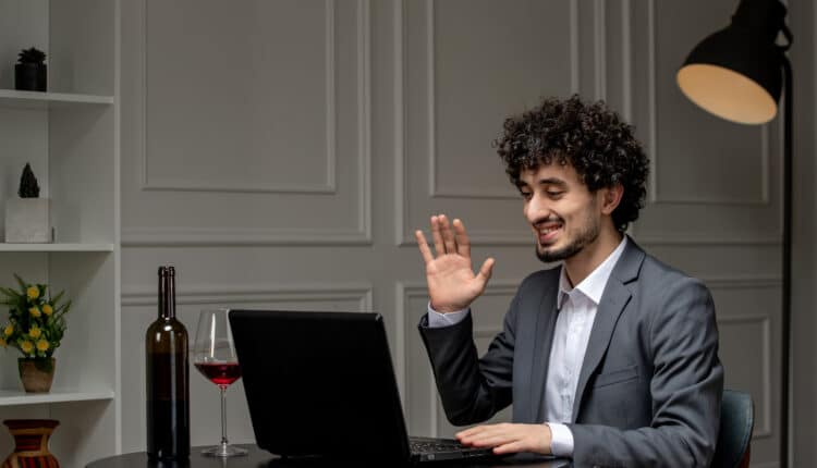 Business professional attending a virtual remote work meeting from home using laptop.