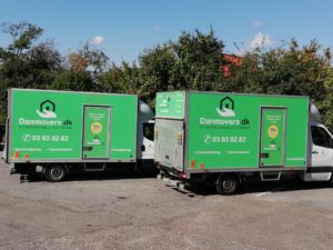 to danmovers flyttevogne parkeret udenfor med logo og tilbud på siden af bilenerne
