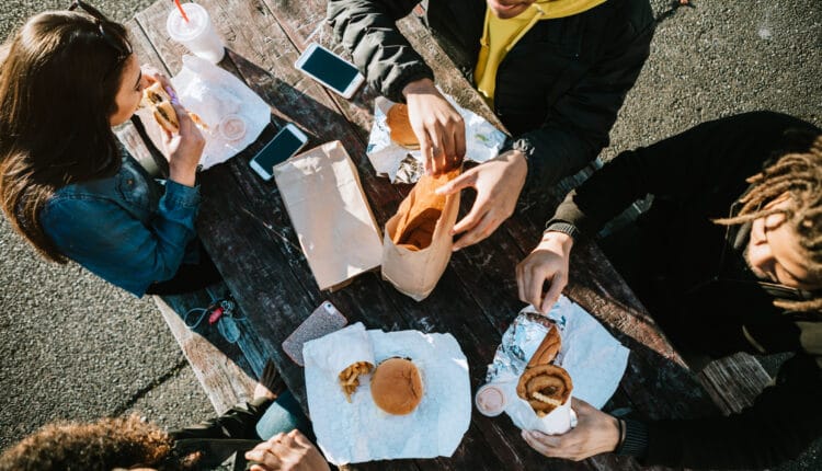 Elever sidder og spiser mad ved et bord.