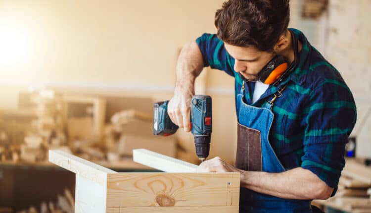 Tømrer borer et hul med en elektrisk boremaskine